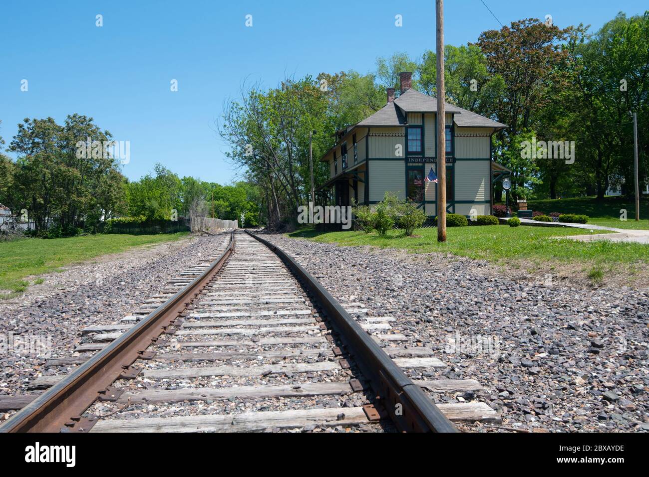 A low level view of a single track railway line on a sunny day, with the Chicago and Alton Railroad Depot building on the right hand side Stock Photo