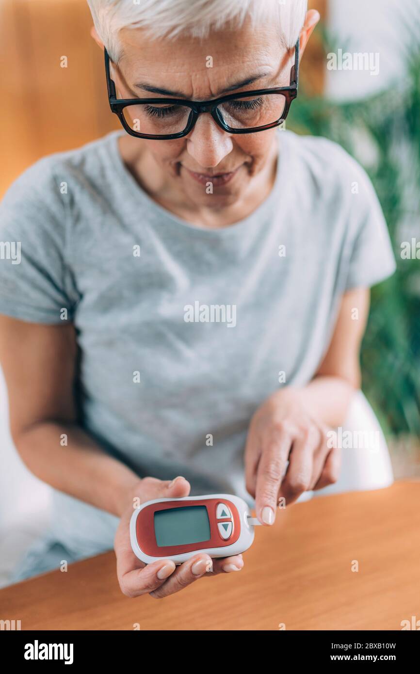 Diabetic measuring blood glucose levels Stock Photo