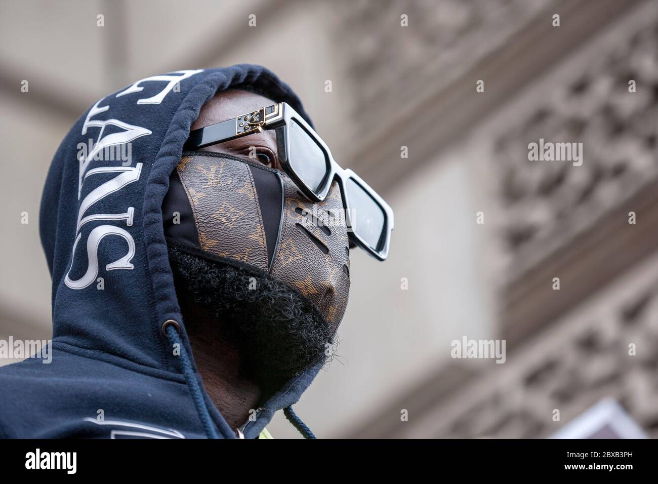 Man wearing a hooded top, sunglasses and Louis Vuitton Face Mask, at the  Black Lives Matter UK protest in Parliament Square. London, England UK  Stock Photo - Alamy