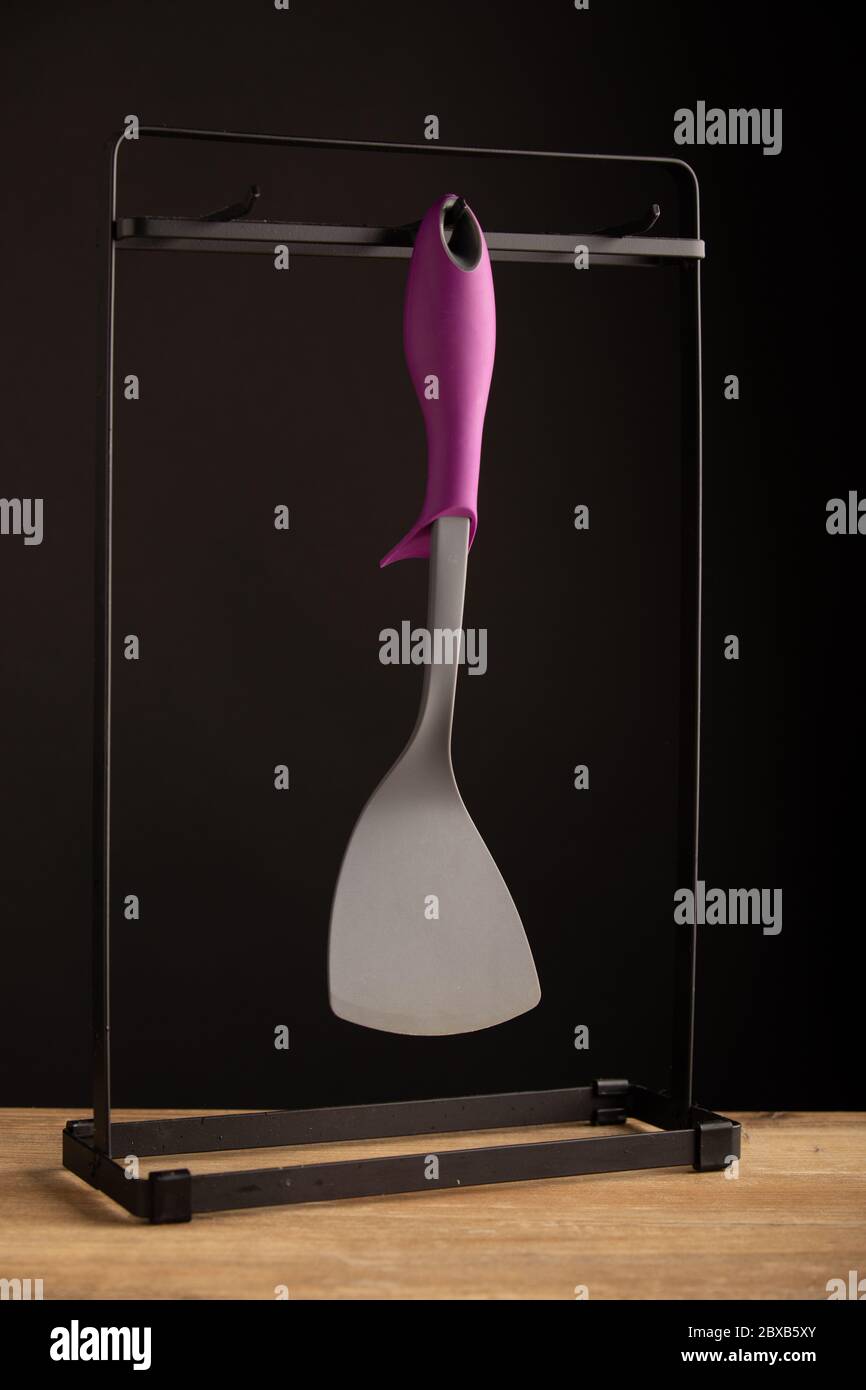 A plastic spatula for a meal on a black background Stock Photo