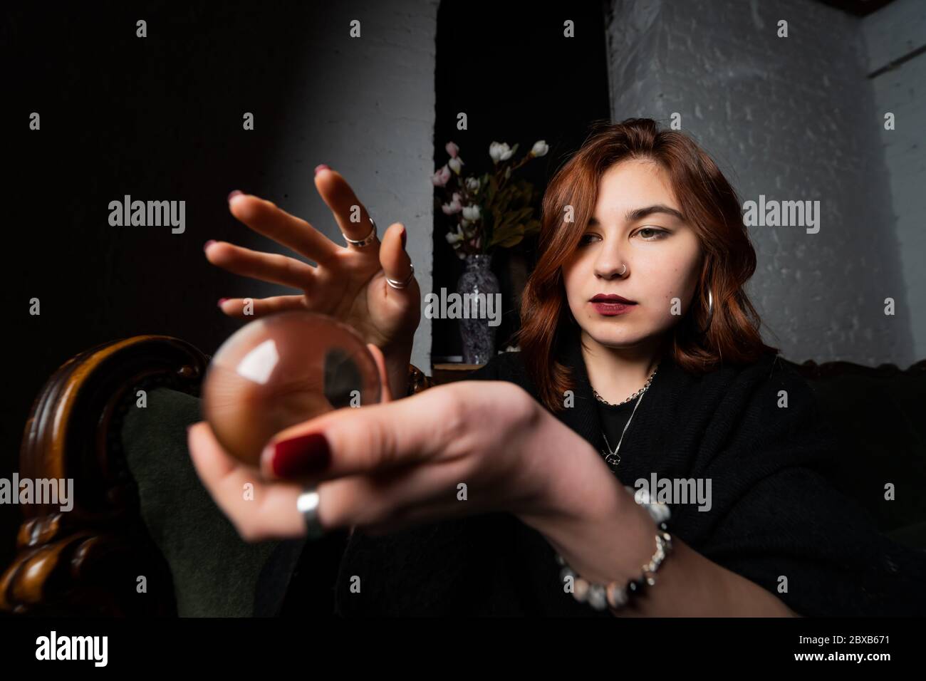Woman in black suit holding crystal ball Stock Photo - Alamy