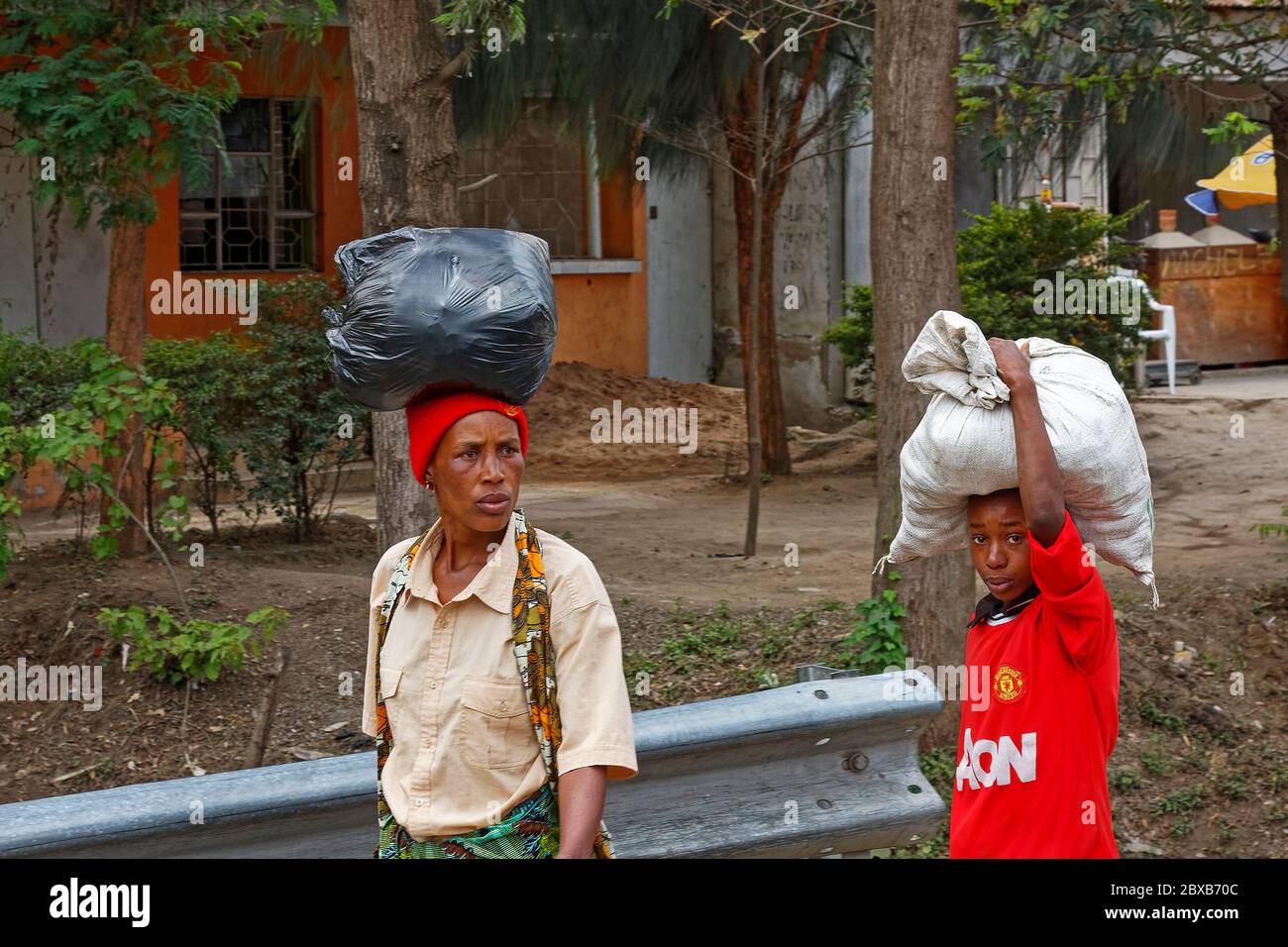 woman; boy; carrying bags on head; walking; street scene; people,  lifestyle; Africa, Arusha; Tanzania Stock Photo - Alamy