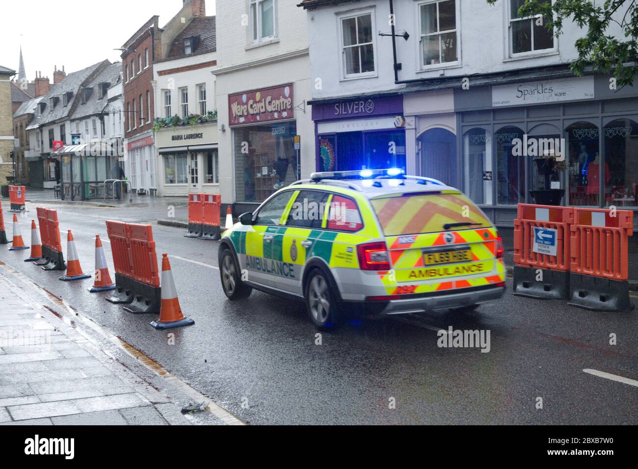 Ware, UK. 6th June, 2020. Rainfall and thunderstorms over Hertfordshire, UK. The main road through Ware has been turned in to a one way street to help with social distancing and to help prevent spread of coronavirus (COVID-19).  An ambulance speeding through the town. Credit: Andrew Steven Graham/Alamy Live News Stock Photo