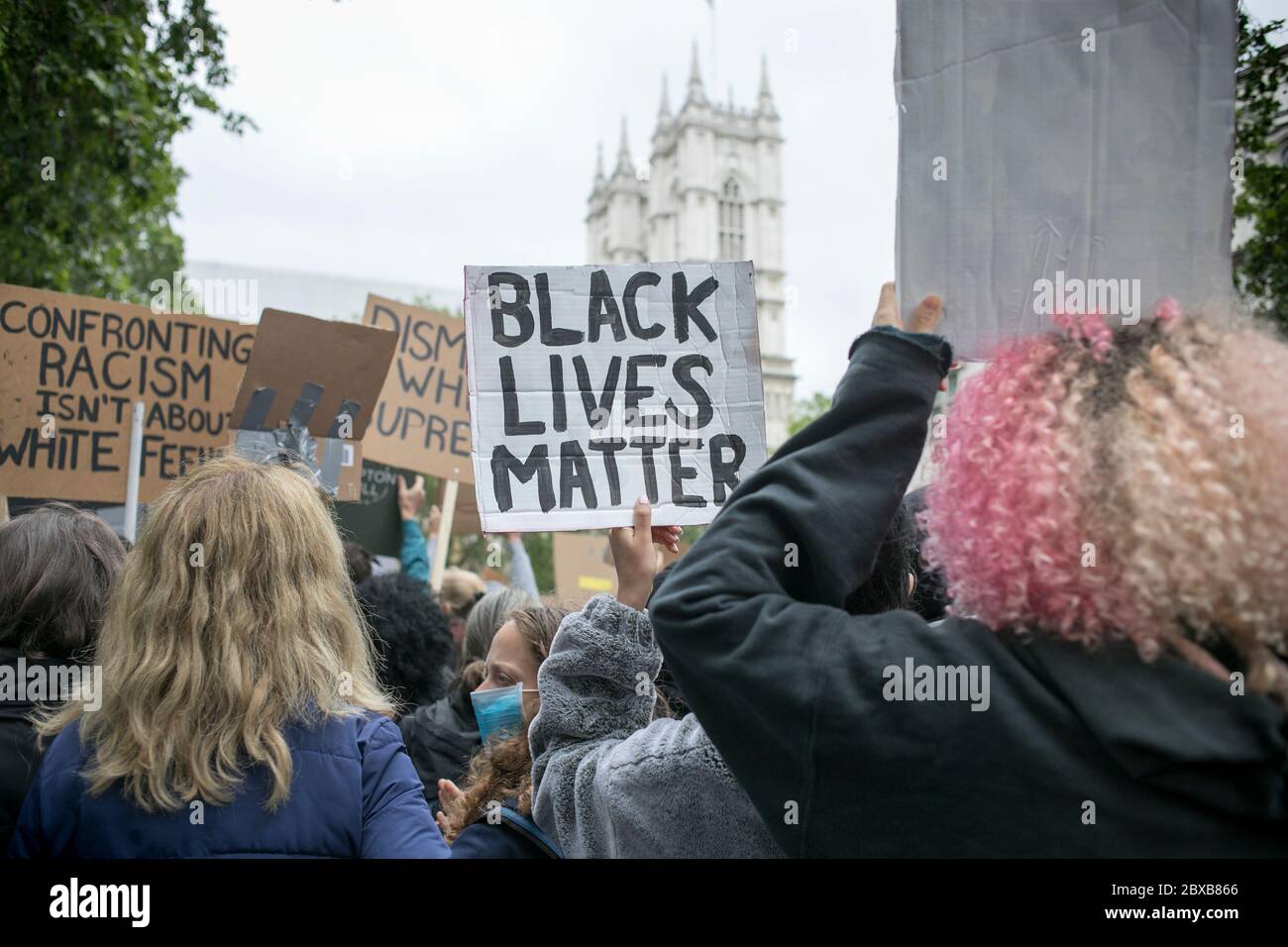 Protestors holding placards facing Westminster Abbey during the rally against systemic racism in the UK held in central London. Stock Photo
