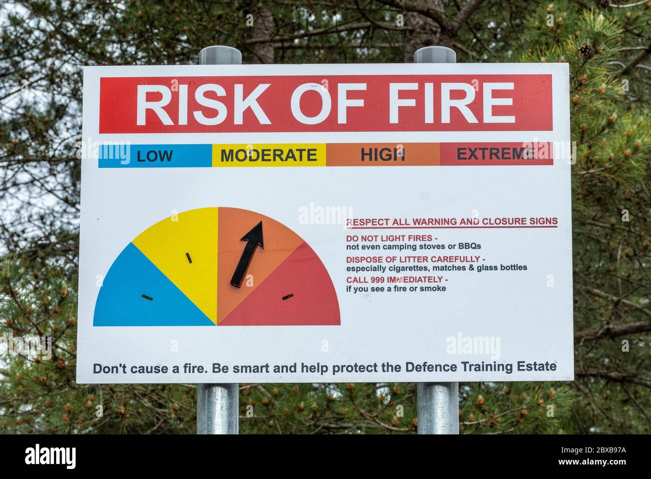 Risk of Fire warning sign with arrow pointing to high risk, notice on Defence Training Estate (MOD land, heathland), Hankley Common, Surrey, UK Stock Photo