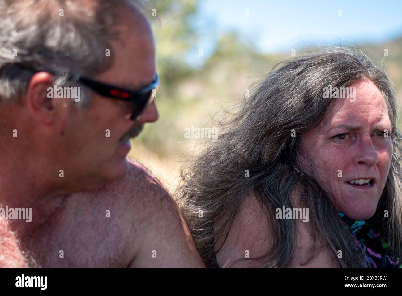 A couple poses for a photo while they rest after a hike in Yolo County, CA. Stock Photo