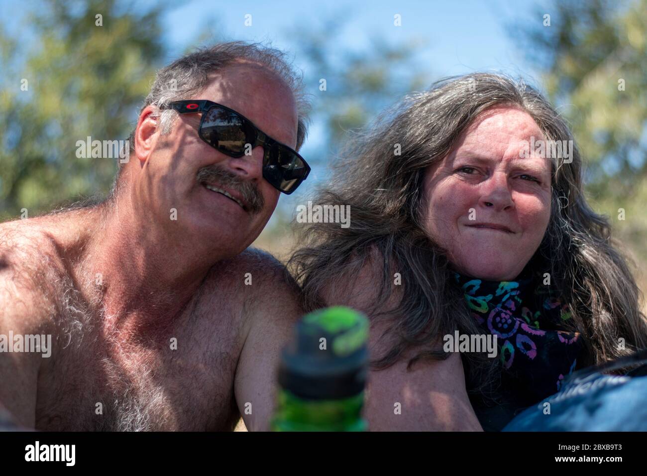 A couple poses for a photo while they rest after a hike in Yolo County, CA. Stock Photo