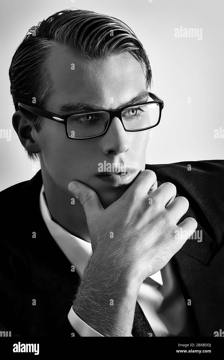 Thoughtful young businessman. Handsome blonde man with glasses looking at infinity. Black and white portrait Stock Photo