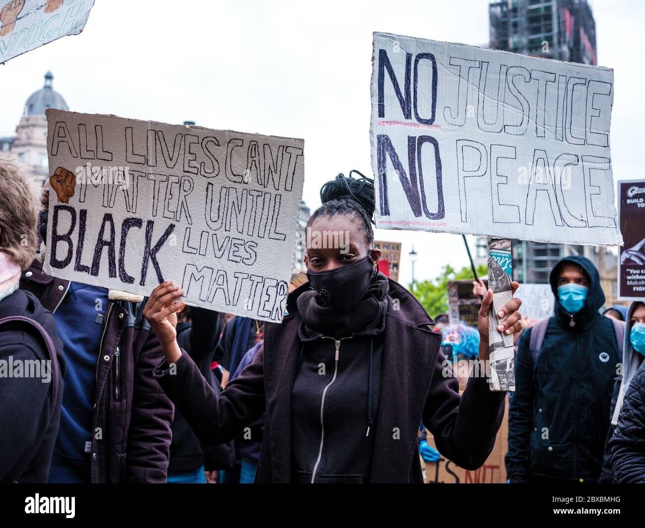 London, UK. 6th June, 2020. A protestor holds two placards during the Black Lives Matter Protest in Parliament Square in London.  In memory of George Floyd who was killed on the 25th May while in police custody in the US city of Minneapolis. Credit: Yousef Al Nasser/Alamy Live News. Stock Photo