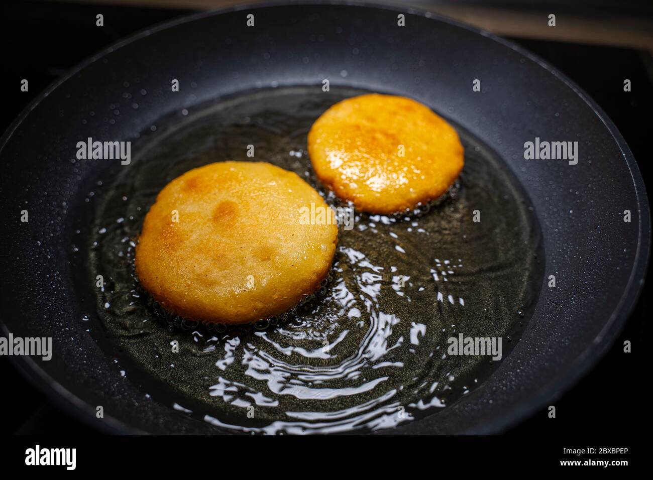 Venezuelan arepas recipe. Frying in a pan with oil. Stock Photo