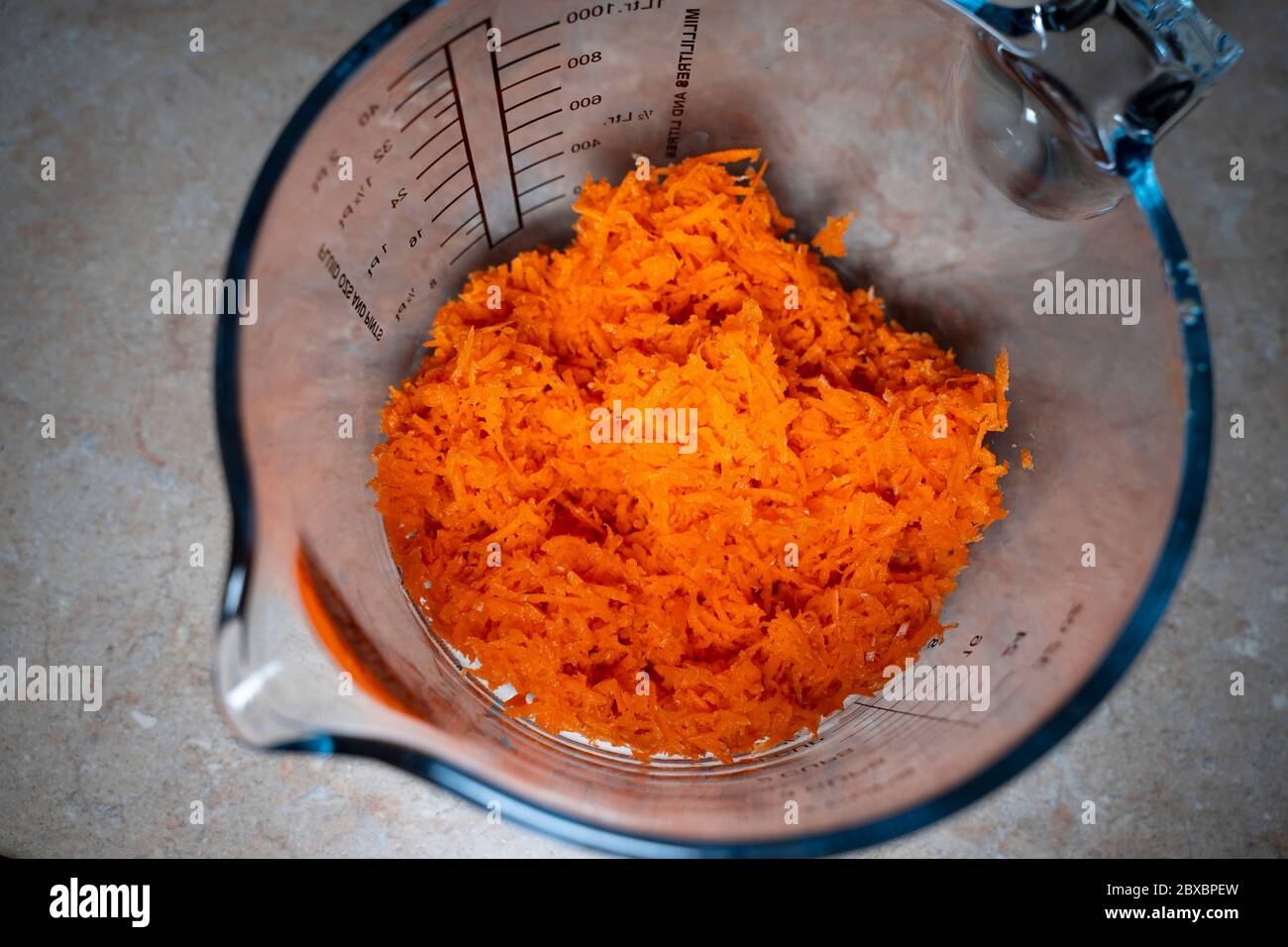 Grated carrot in a measuring cup. Top view Stock Photo Alamy