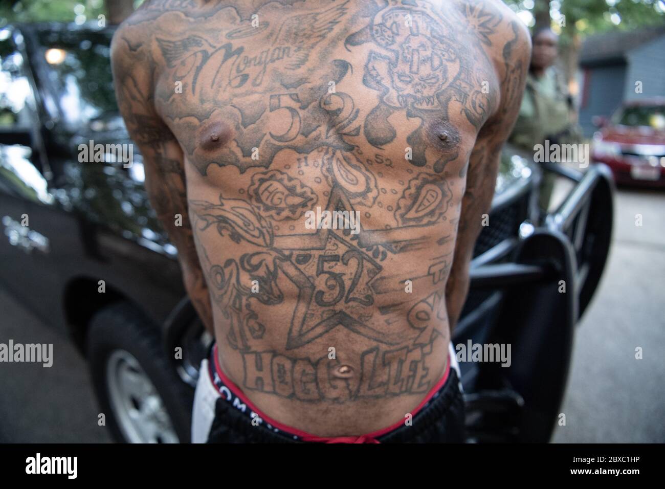 A gang members has his chest tattoos documented by U.S. Marshals after he was arrested for violent offenses during the two-week long Operation Bluff City Blues August 20, 2019 in Memphis, Tennessee. The initiative resulted in the arrests of 214 individuals in West Tennessee. Stock Photo