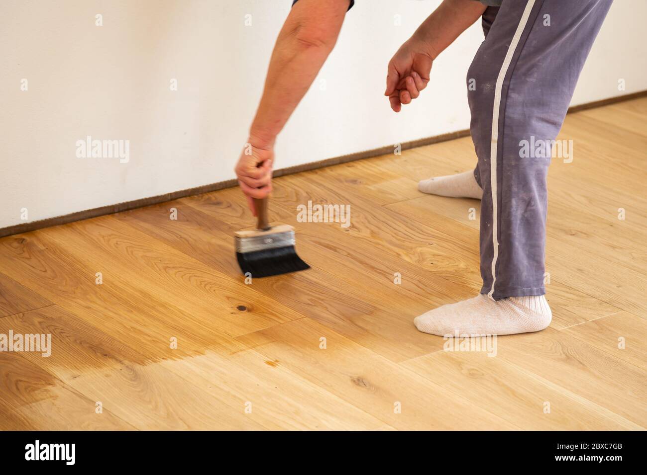 Application of oilbased floor finish on luxury oak parquet flooring