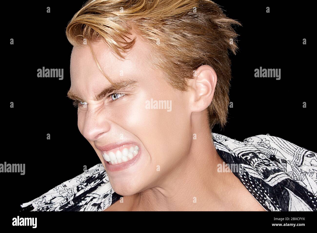 Side view of snarling young man. Closeup portrait isolated on black. Rage concept Stock Photo