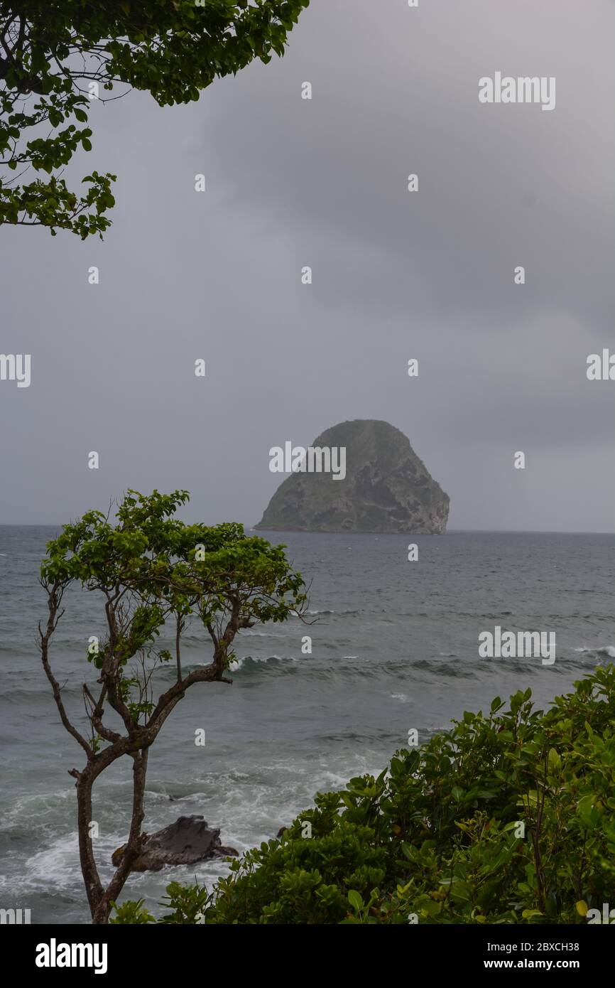 Landscape seascape view of the famous Diamond rock (rocher du Diamant) in the lumpy sea with grey sky and clouds, Martinique, Antilles, West Indies Stock Photo