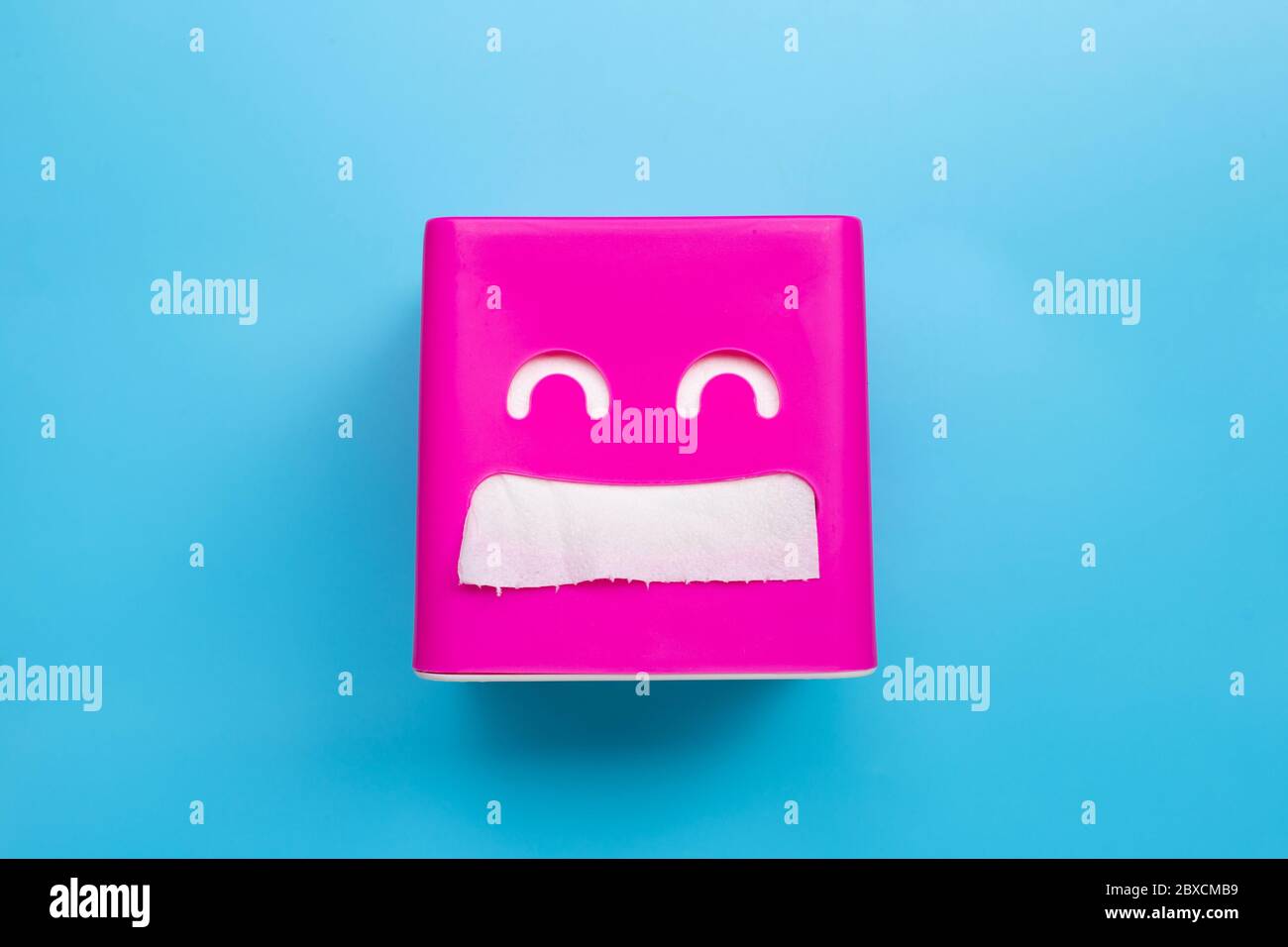 Pink tissue paper box on blue background. Copy space Stock Photo
