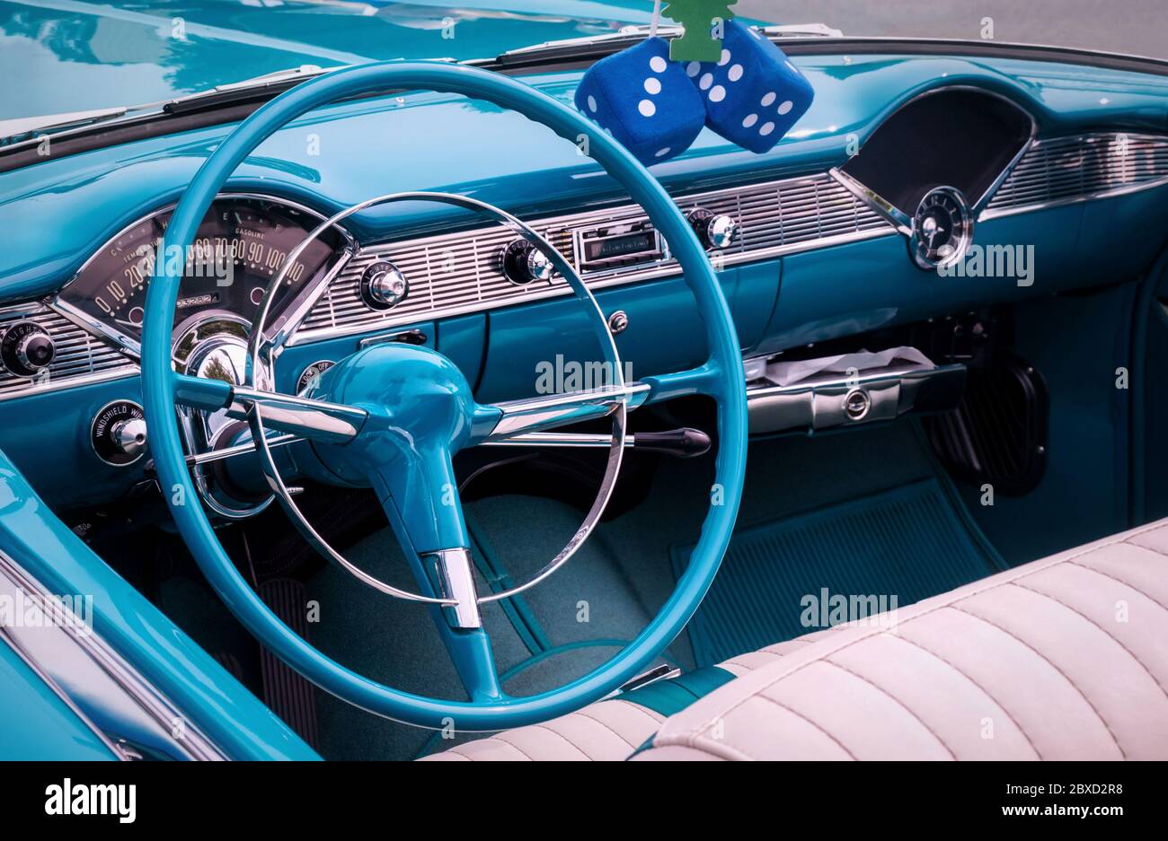 Steering wheel, speedometer, clock, radio scale, buttons and knobs on front panel of blue convertible coupe old timer car Stock Photo