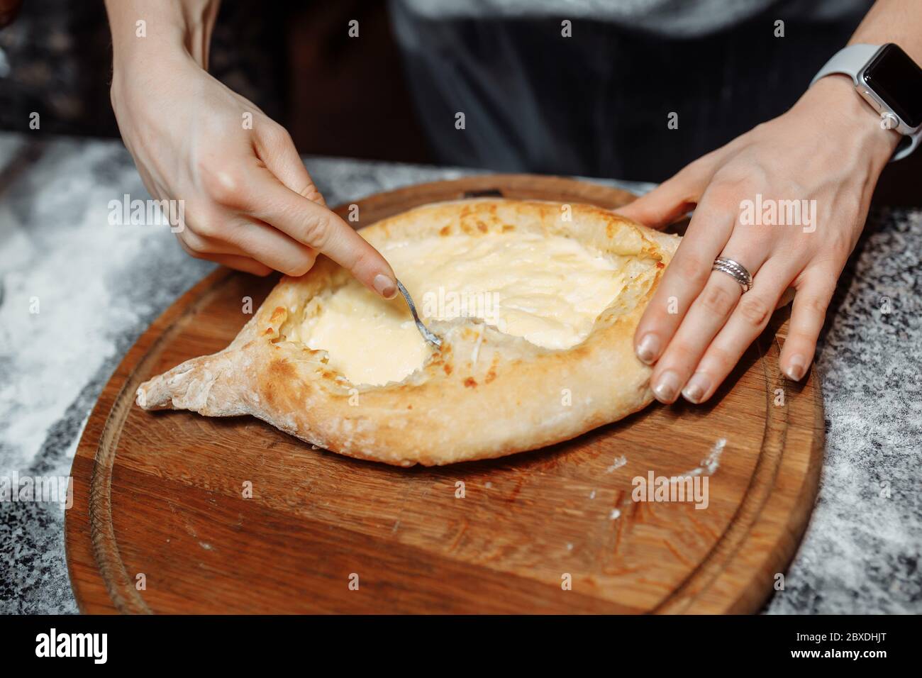 Chef cooking khachapuri with cheese and egg. Georgian national cuisine Stock Photo