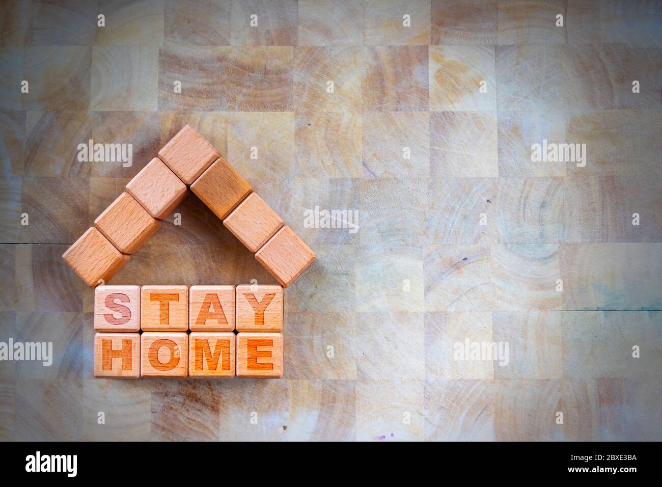 Stay home to stay safe due to Covid-19 coronavirus outbreak pandemic. Concept of self isolation or quarantine message engraved on wooden blocks on woo Stock Photo