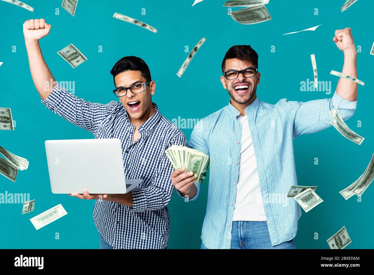 Sports Betting Online. Happy hispanic guys celebrating victory with laptop and cash Stock Photo
