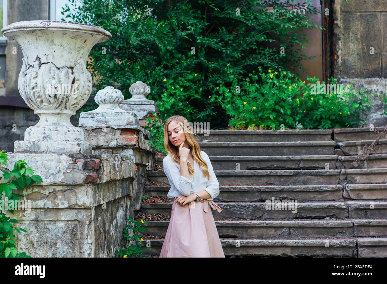 Portrait of a girl standing next to an old building with a decorative ...