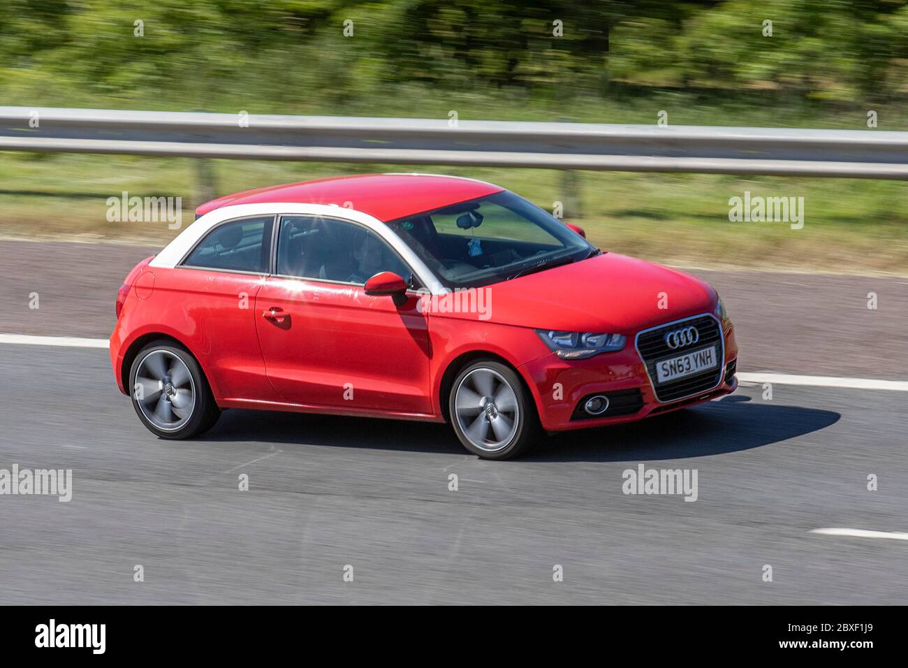 2013 red Audi A1 Sport TFSI; Vehicular traffic moving vehicles, cars driving vehicle on UK roads, motors, motoring on the M6 motorway Stock Photo