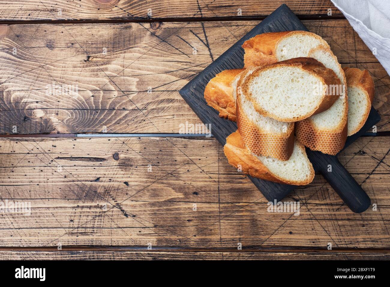 Fresh white bread baguette cut slays on a wooden cutting Board Copy space. Stock Photo