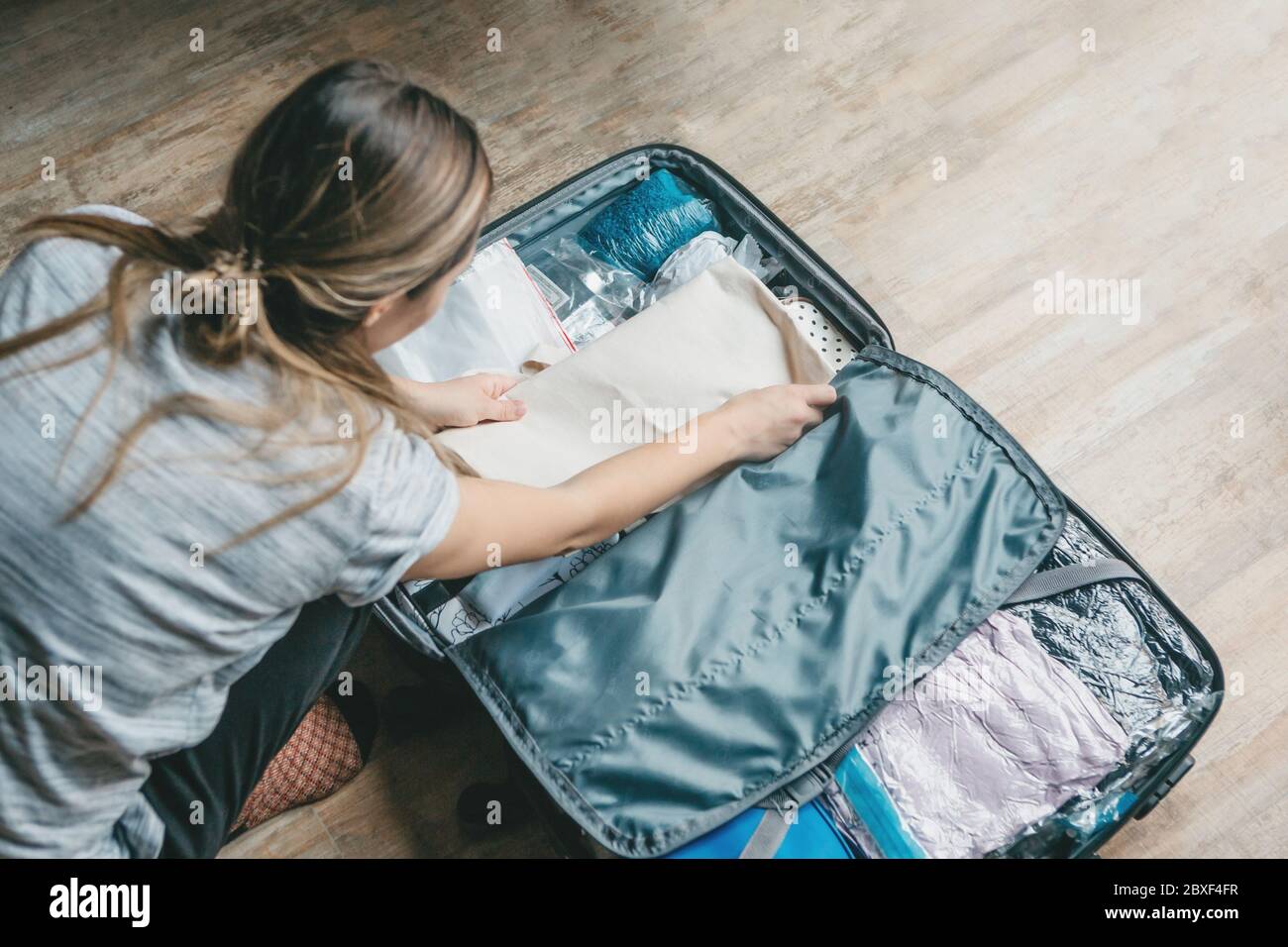 attractive girl packing suitcase for vacation Stock Photo - Alamy