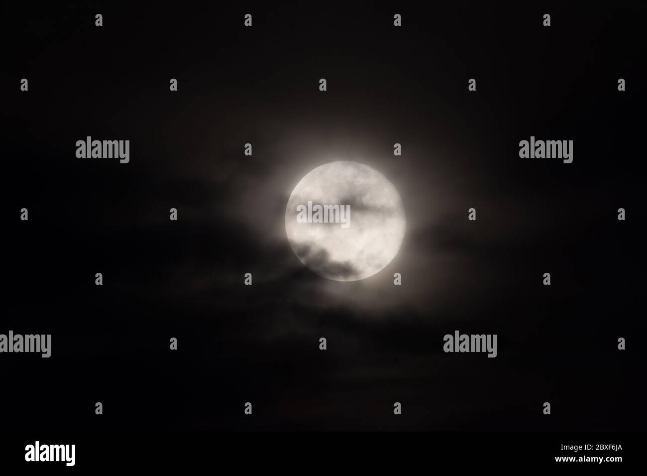 full moon under heavy clouds Stock Photo