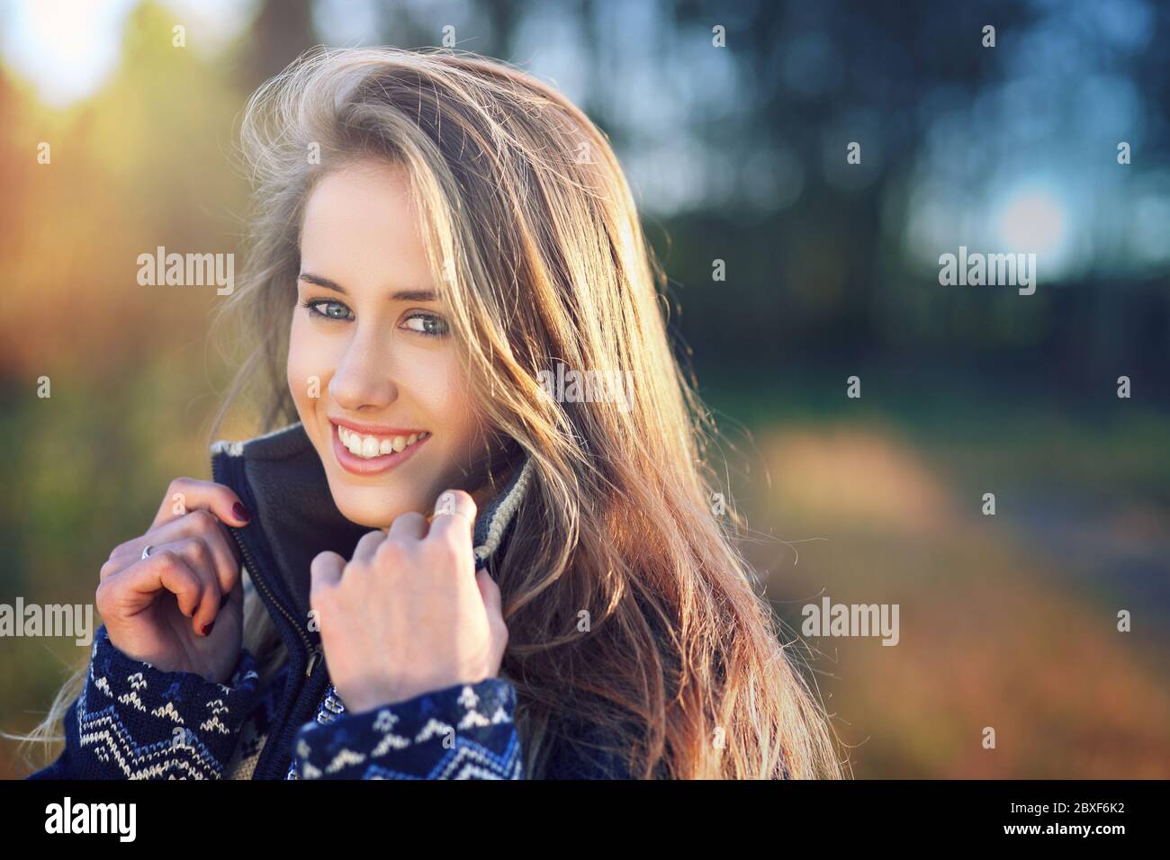 Natural backlight portrait of a smiling girl in sunset light. Stock Photo