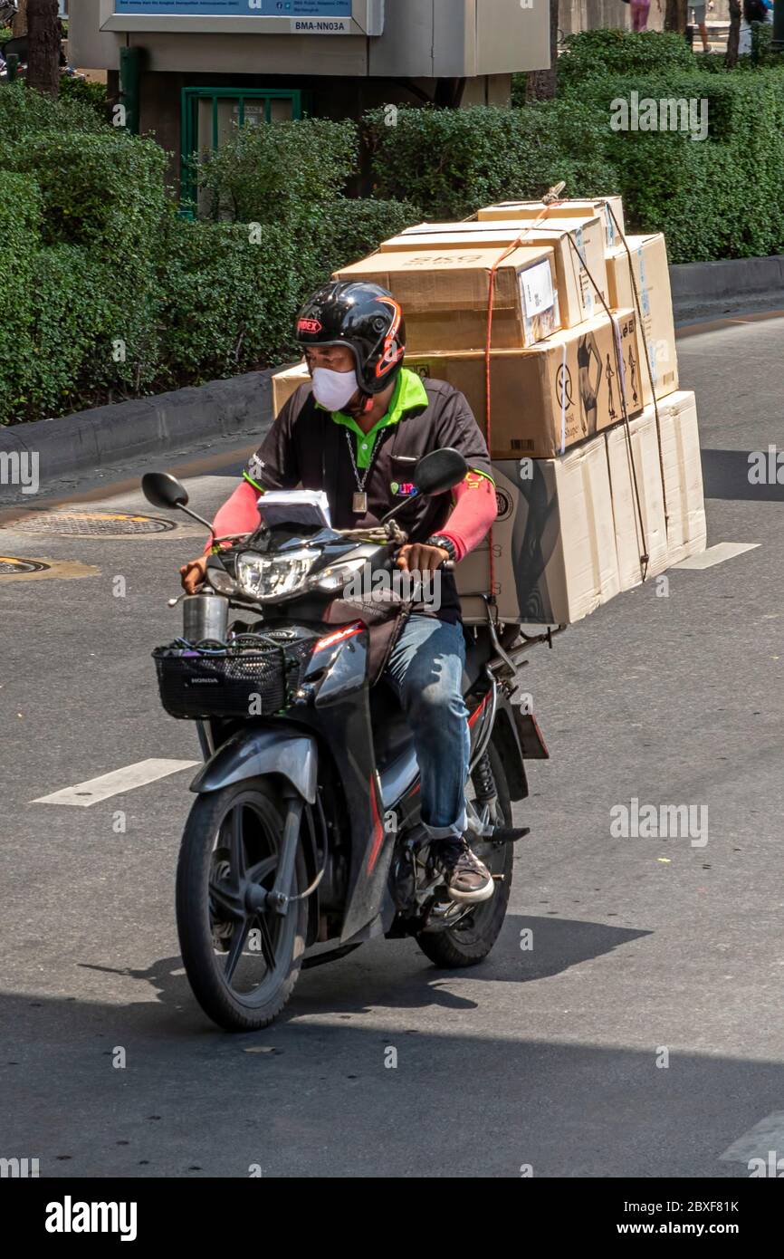 Motorcycle delivery with face mask during Covid pandemic, Bangkok, Thailand Stock Photo