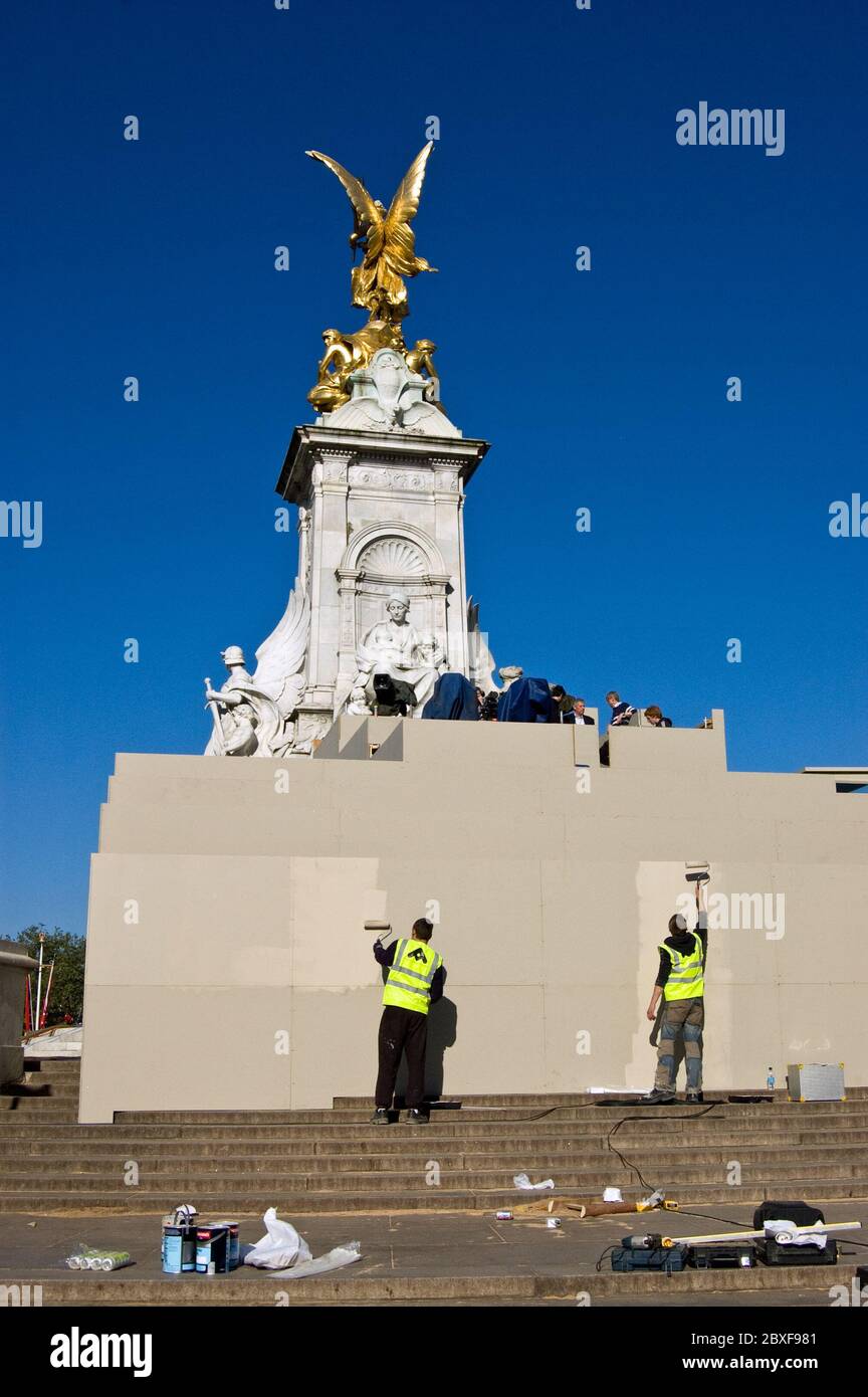 London, UK - April 27, 2011:  Workmen painting a hoarding around the Victoria Memorial outside Buckingham Palace ahead of the Royal Wedding of Prince Stock Photo