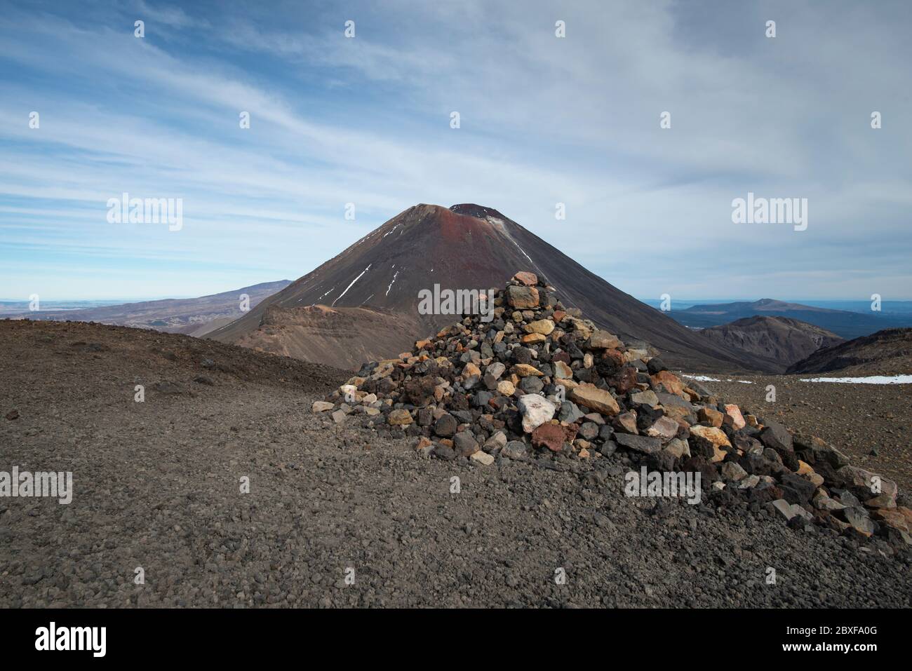 View of Mount Ngauruhoe with a pile of rocks in the foreground on the Tongariro Alpine Crossing Stock Photo