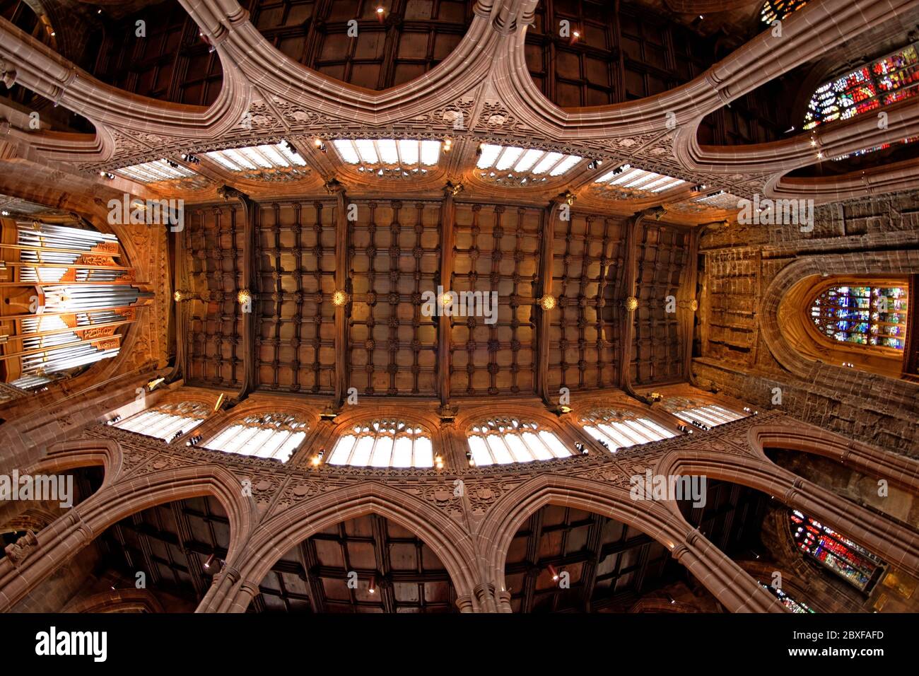 Manchester Cathedral nave with the magnificent arched walls and windows, its robust wooden ceiling supported by fourteen musical angels Stock Photo