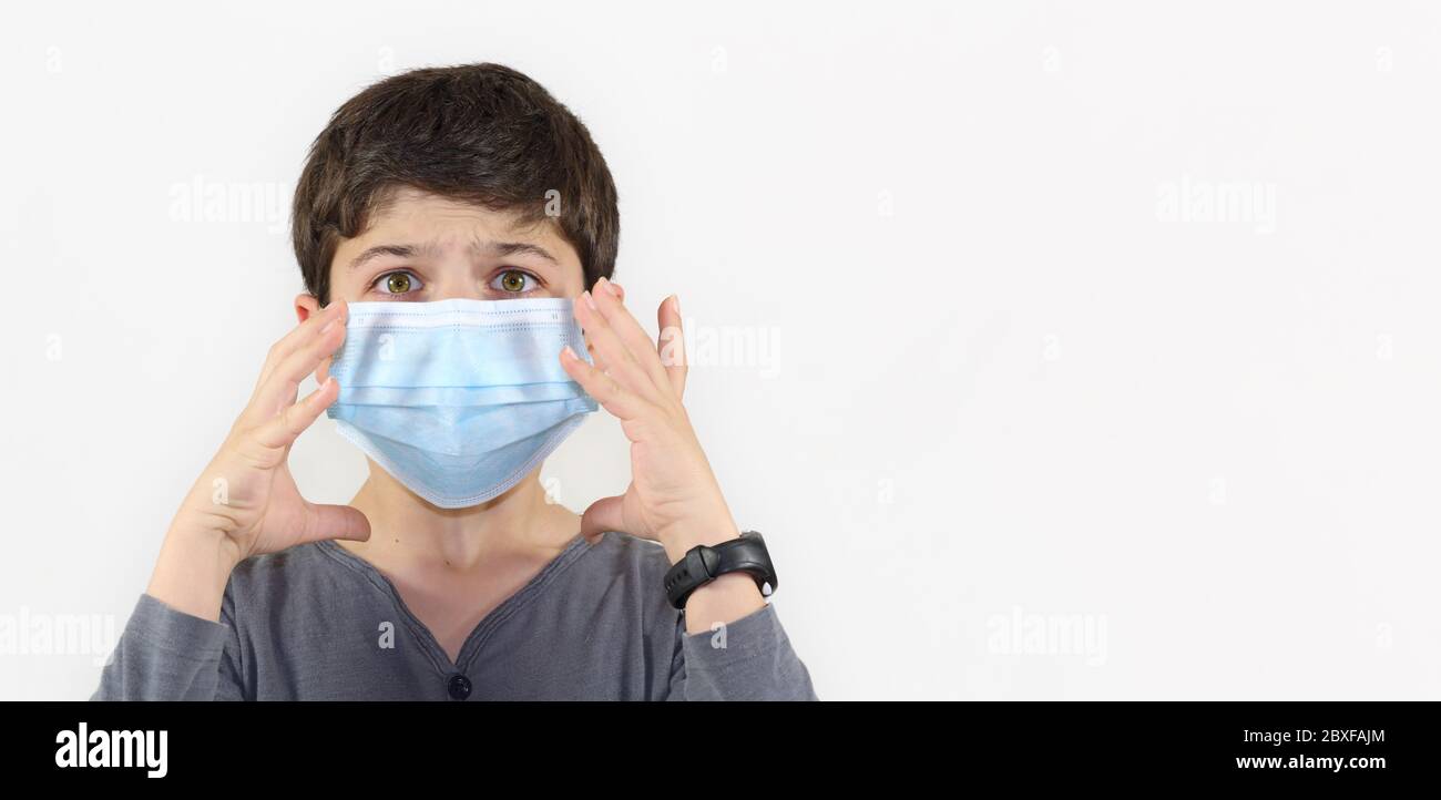 child with a surgical mask on the face - Covid-19 coronavirus barrier gesture child with surgical mask frightened by the epidemic Stock Photo
