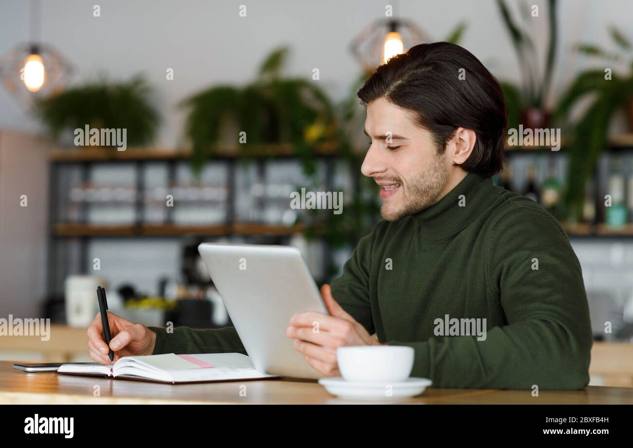 Freelancer working on new project at cafe, using digital tablet Stock Photo