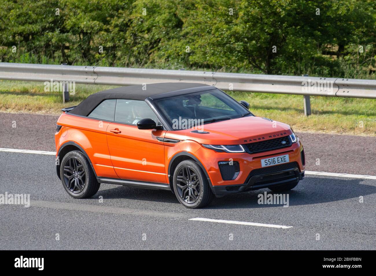 2016 orange Land Rover R Rover Evoque HSE DYN TD; Vehicular traffic moving vehicles, cars driving vehicle on UK roads, motors, motoring on the M6 motorway highway convertible, convertibles, soft-top, open topped, roadster, cabriolets, drop-tops Stock Photo