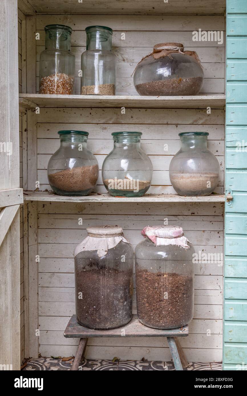 Wooden garden closet with large glass jars filled with diffrent kinds