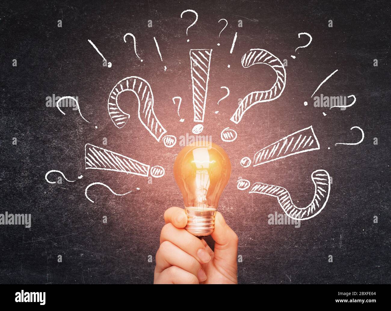 Solution to problem. Hand holding glowing light bulb with question