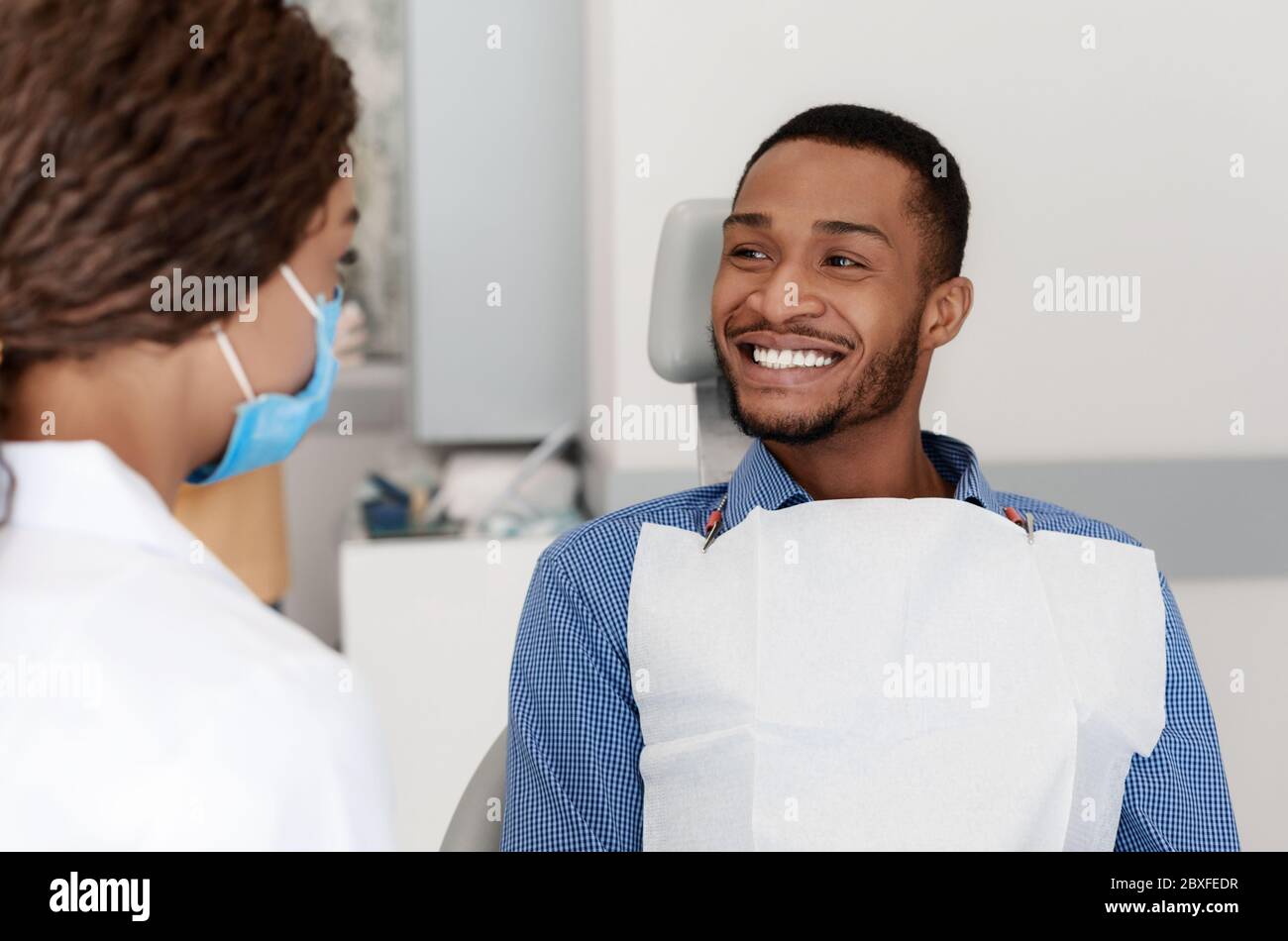 Young black man smiling to female dentist doctor Stock Photo Alamy