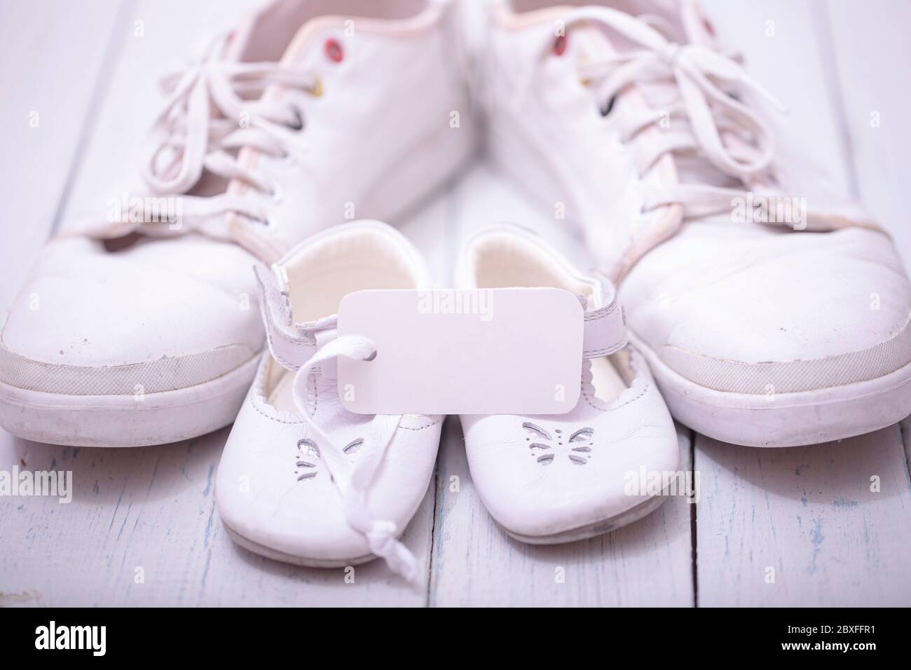 Daddy's baby's sneakers, on white wooden background, fathers day concept. Stock Photo