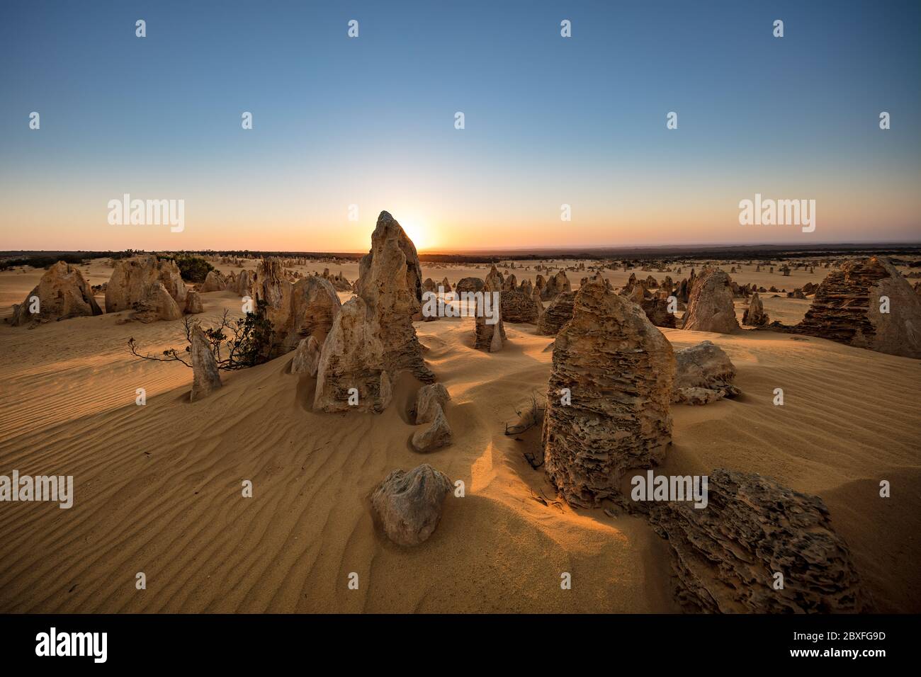 Sun setting behind the limestone stacks in the Pinnacles desert in the Nambung national park located north of Perth in Western Australia Stock Photo