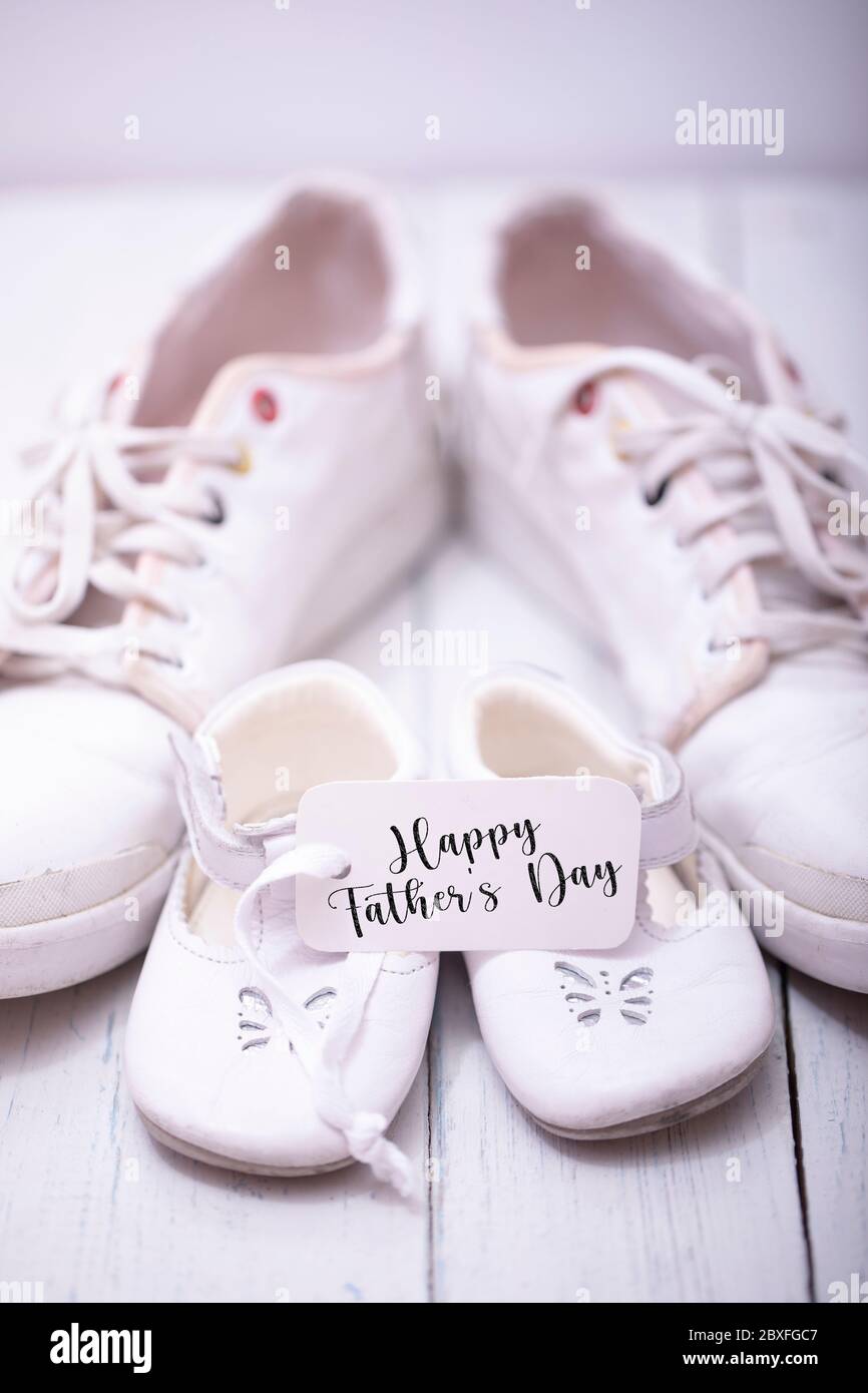 Man's and kid's shoes on white wooden background. Happy father's day concept. Stock Photo