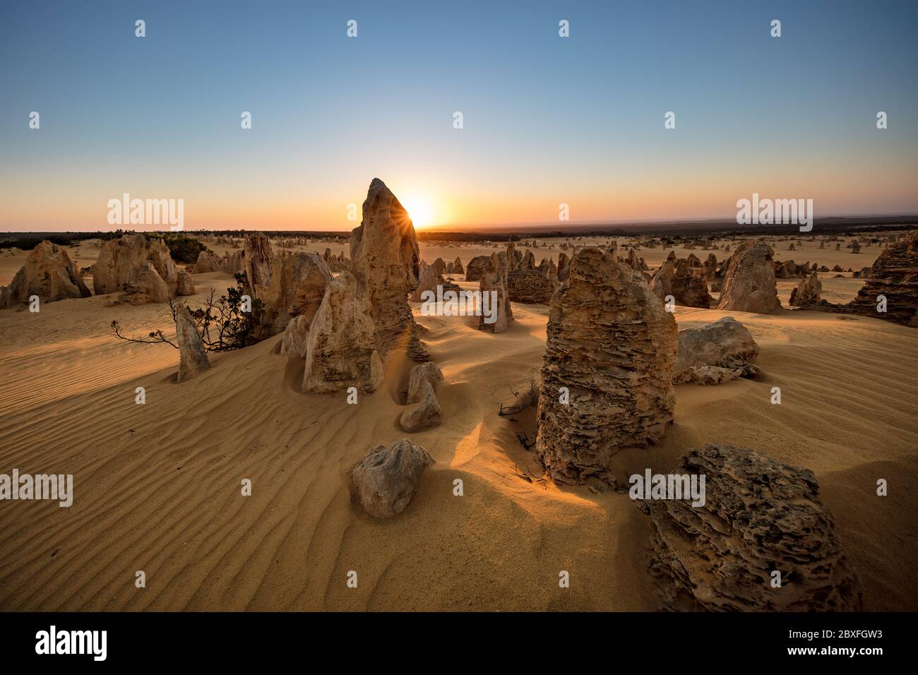 Sun setting behind the limestone stacks in the Pinnacles desert in the Nambung national park located north of Perth in Western Australia Stock Photo