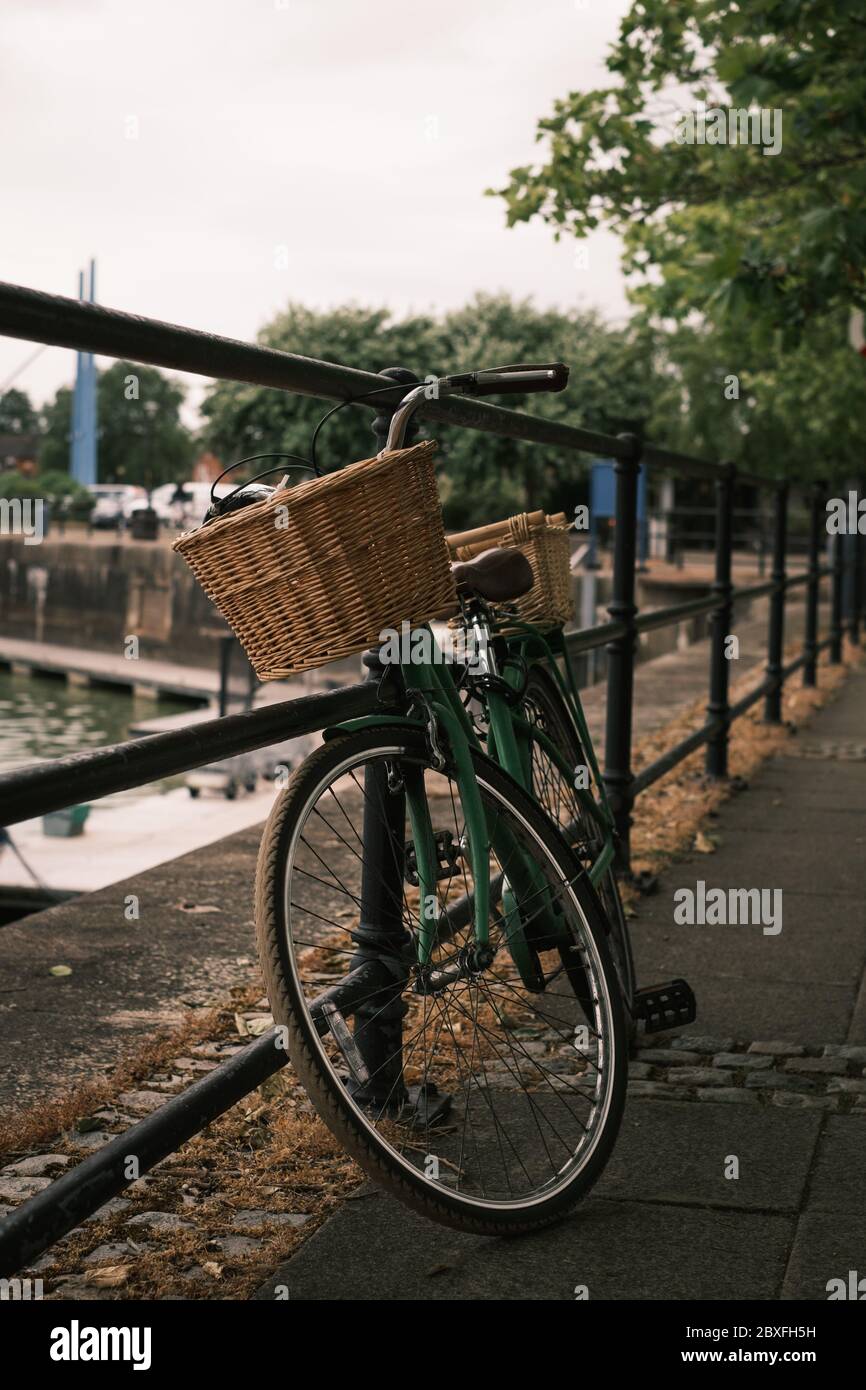 A traditional bike with baskets leaning against railings Stock Photo