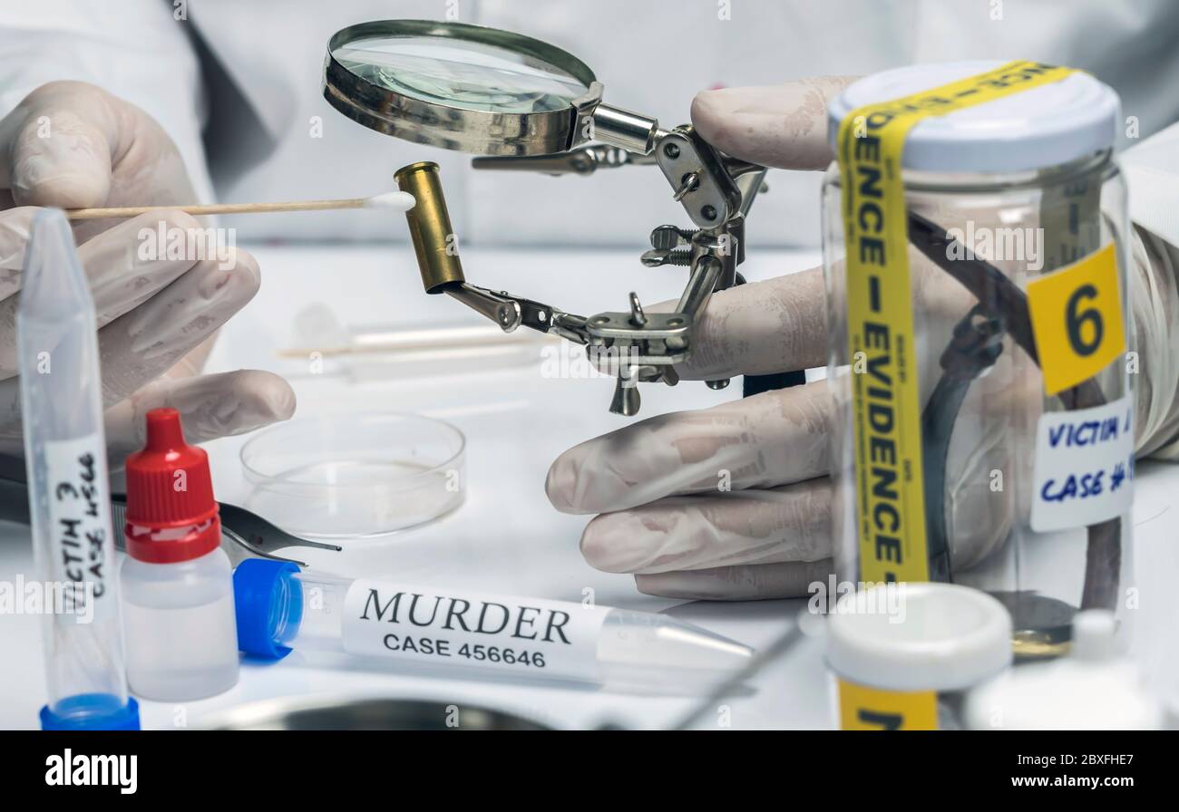 Scientific police examining a bullet cap in ballistic Laboratory ...