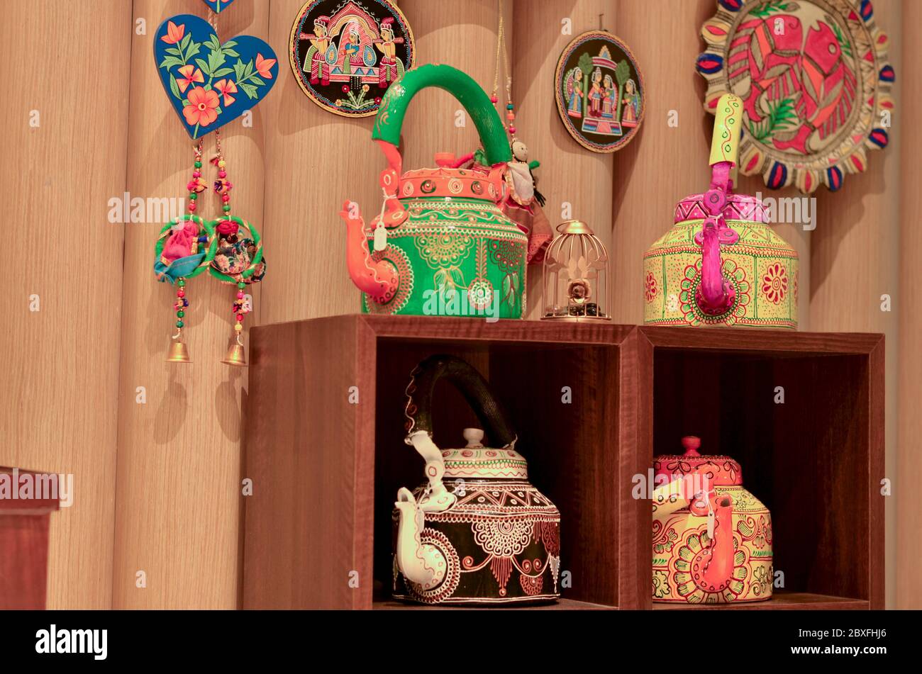 Painted colorful decorative traditional Indian kettles, dreamcatchers and wind chimes on display in a retail store in Dilli Haat, New Delhi, India Stock Photo