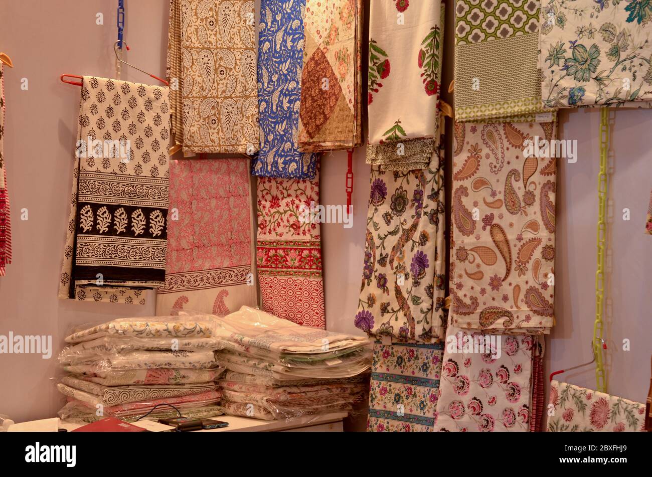Fancy sarees / unstitched suits hanging and folded on display in a