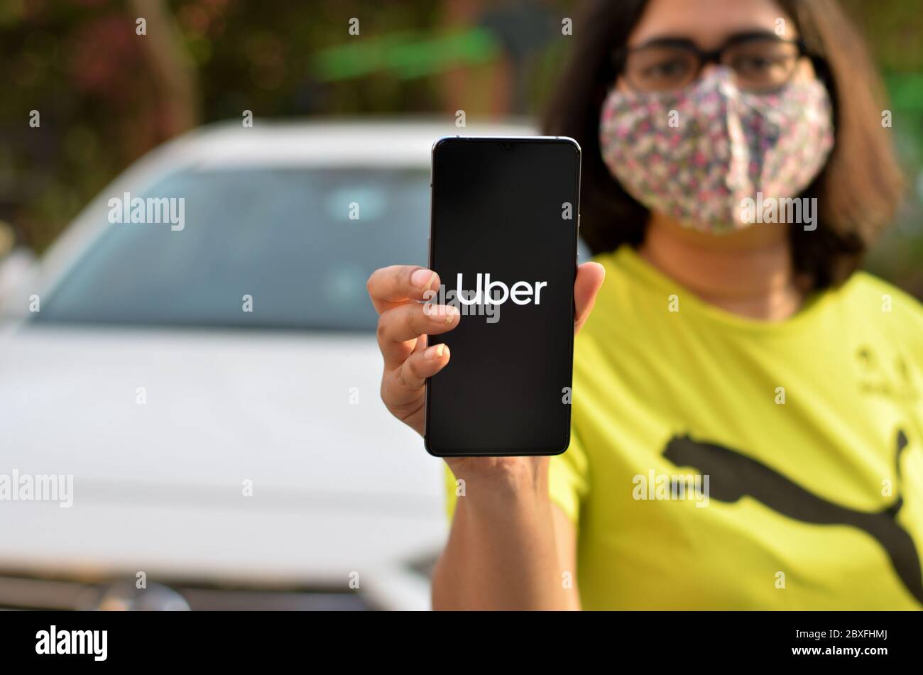 New York, USA, 2020. Girl wearing mask showing Uber app on her 