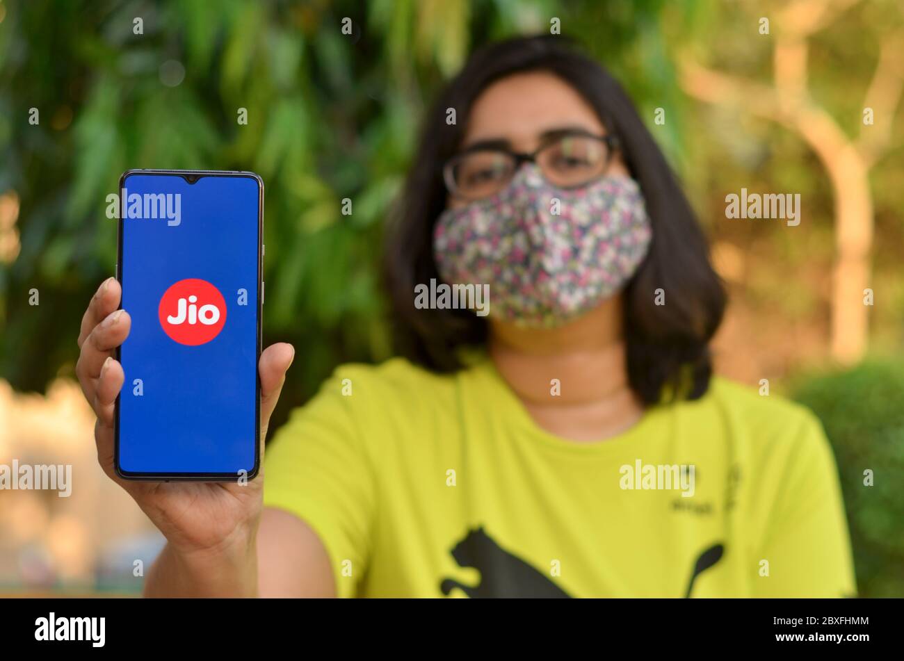 Mumbai, India, 2020. Girl wearing face mask showing Reliance Jio landing page on her mobile screen during Corona Virus (Covid-19) pandemic. Internet u Stock Photo
